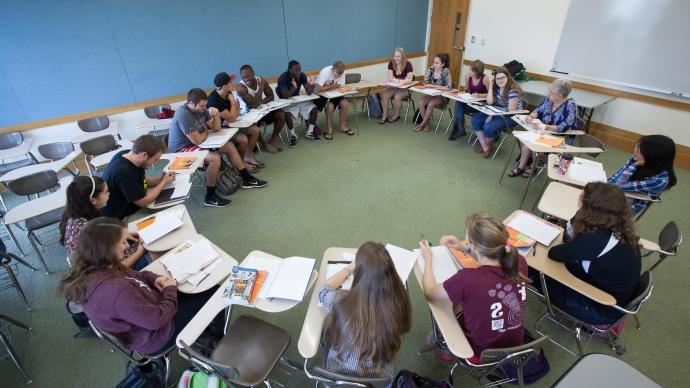 Dr. 科琳·格里森(colleen Grissom)带领一群学生围成一个大圈，在教室里进行讨论.