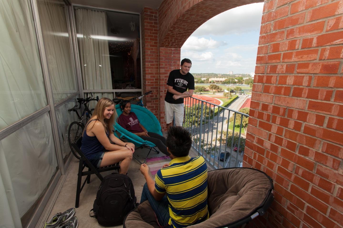 Students hanging out on a balcony in Trinity’s residence halls