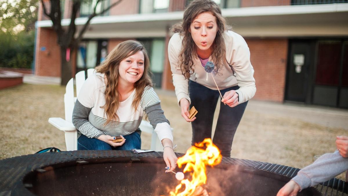 学生们在春季新生迎新活动中围在营火旁的照片