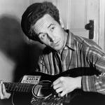 Woody Guthrie with guitar black and white photo